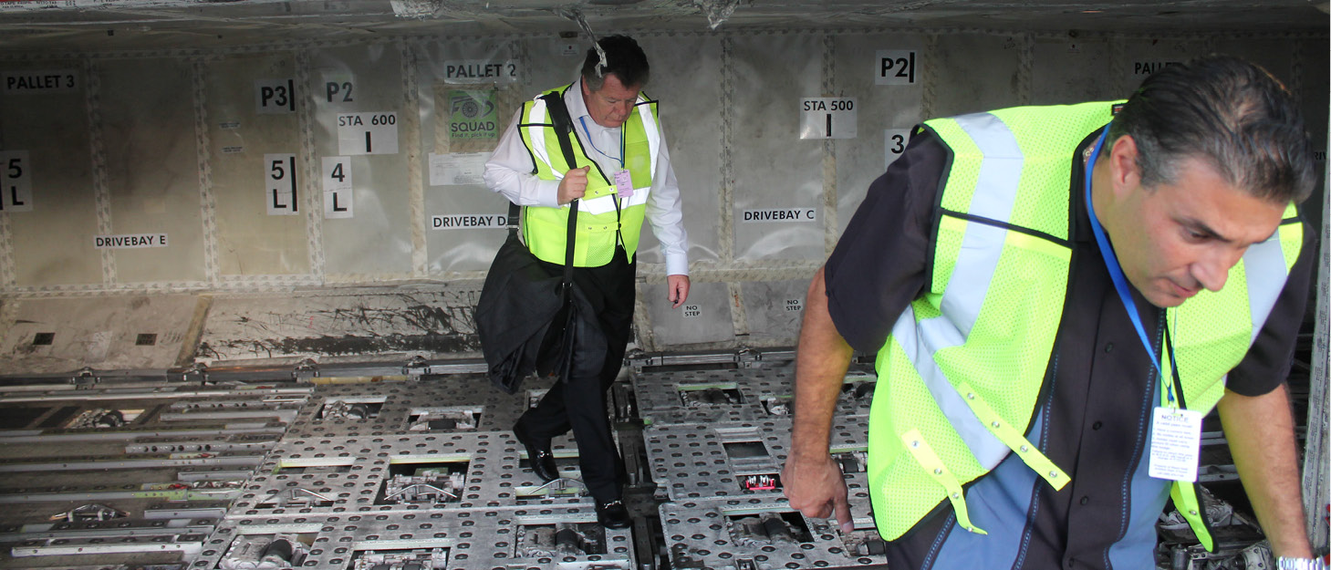 Harry Lombardo and Alex Garcia exit the hold area of a plane